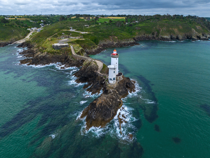 Blick von oben auf den Phare du Petit Minou und die dazugehörige Festungsanlage, umgeben von türkisblauem Wasser und grünen Klippen.