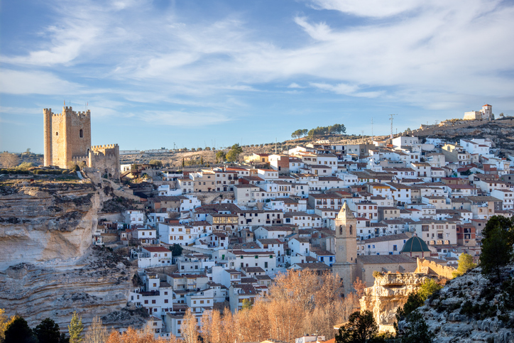 Eine mittelalterliche Burg überragt die weißen Häuser eines malerischen Ortes in Albacete