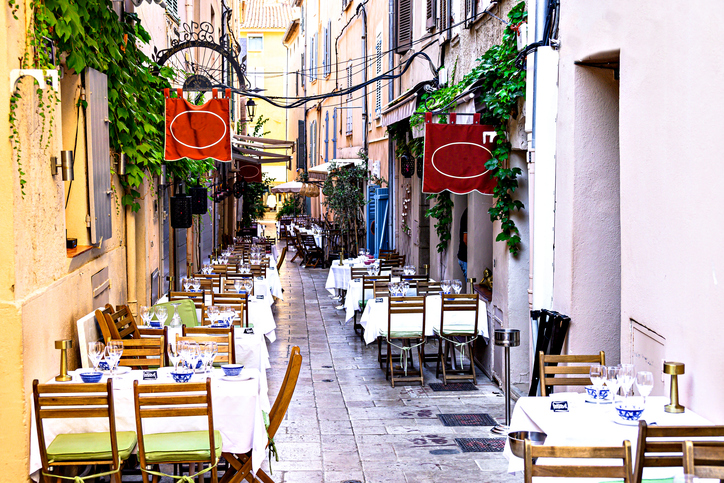 Eine enge, historische Gasse in Saint-Tropez mit liebevoll gedeckten Tischen für ein Restaurant