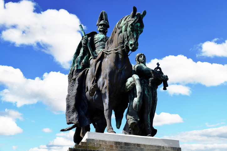 Nahaufnahme des monumentalen Reiterstandbilds von Kaiser Wilhelm I. aus dunkler Bronze vor einem strahlend blauen Wolkenhimmel.