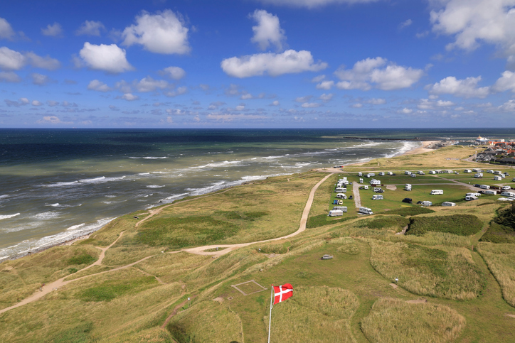 Ein weiter Blick über die grüne Dünenlandschaft und den Campingplatz bis hin zur Nordsee bei Hirtshals