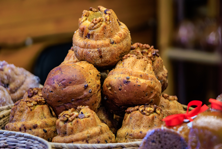 Ein Stapel frisch gebackener Gugelhupf-Kuchen, verziert mit Walnusskernen, in einer Bäckerei.