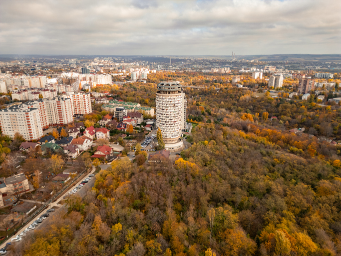 Das runde Wohngebäude "Romanița" umgeben von herbstlich gefärbten Bäumen und Stadtvierteln in Chișinău