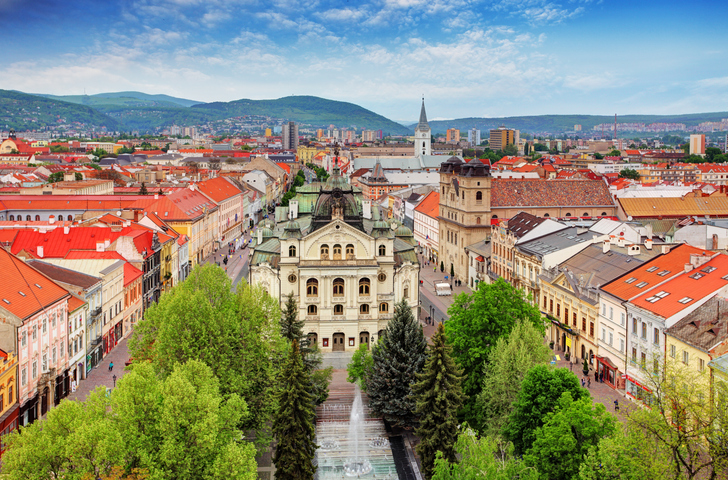 Blick von oben auf das Staatstheater und die Parkanlagen der Hauptstraße in Košice bei strahlendem Sonnenschein.