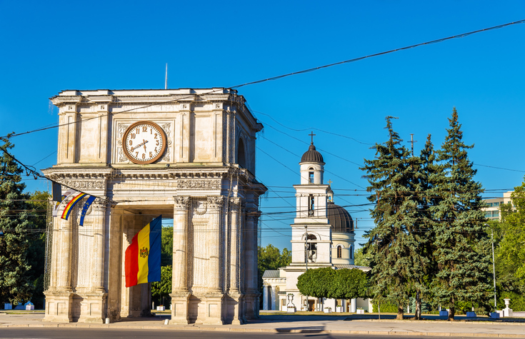 Der historische Triumphbogen mit der moldauischen Flagge neben dem Glockenturm der Kathedrale von Chișinău
