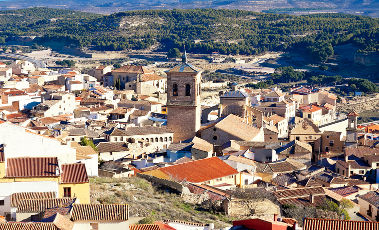 Warme Sonnenstrahlen beleuchten die typischen Terrakotta-Dächer einer Stadt in Albacete