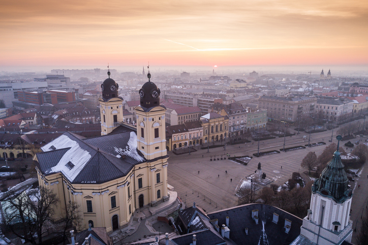 Malerischer Sonnenuntergang über der reformierten Großkirche und der Innenstadt von Debrecen