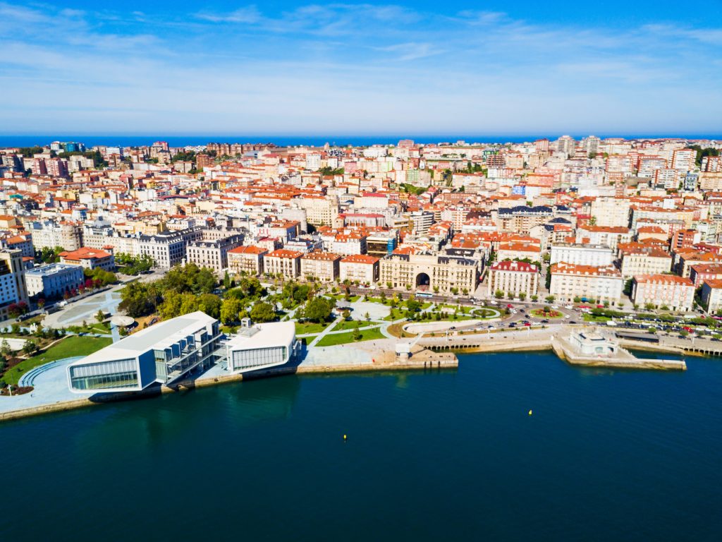 Ein architektonisch auffälliges, weißes Gebäude liegt direkt am tiefblauen Wasser der Bucht von Santander.