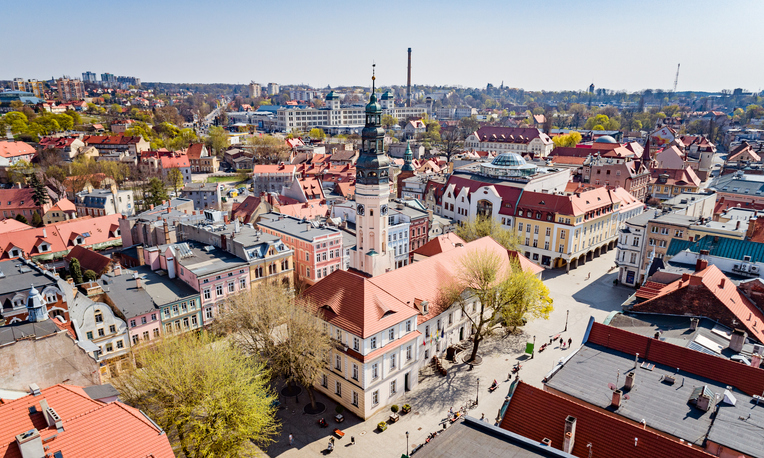 Ein sonniger Blick auf das Zentrum von Zielona Góra mit dem markanten Rathausturm und den roten Ziegeldächern.