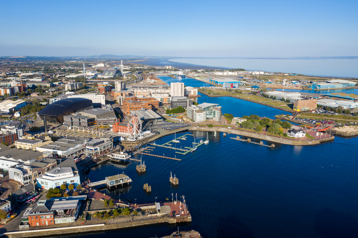 Luftaufnahme von Cardiff Bay mit Hafen, Wasserflächen, moderner Architektur und Blick zur Küste.