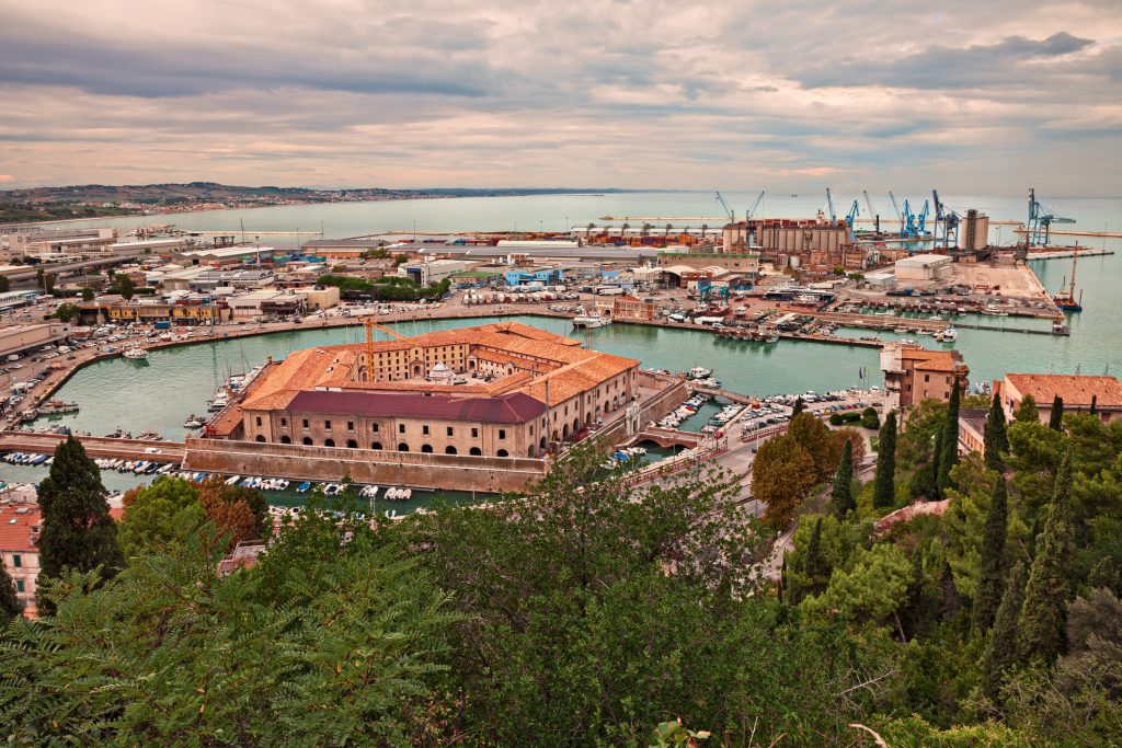 Der Industriehafen von Ancona mit dem Lazarett im Vordergrund unter einem wolkigen Himmel.