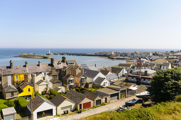 Ein Blick von oben auf die charmante Hafenstadt Donaghadee mit ihren bunten Häusern und dem Leuchtturm im Hintergrund.