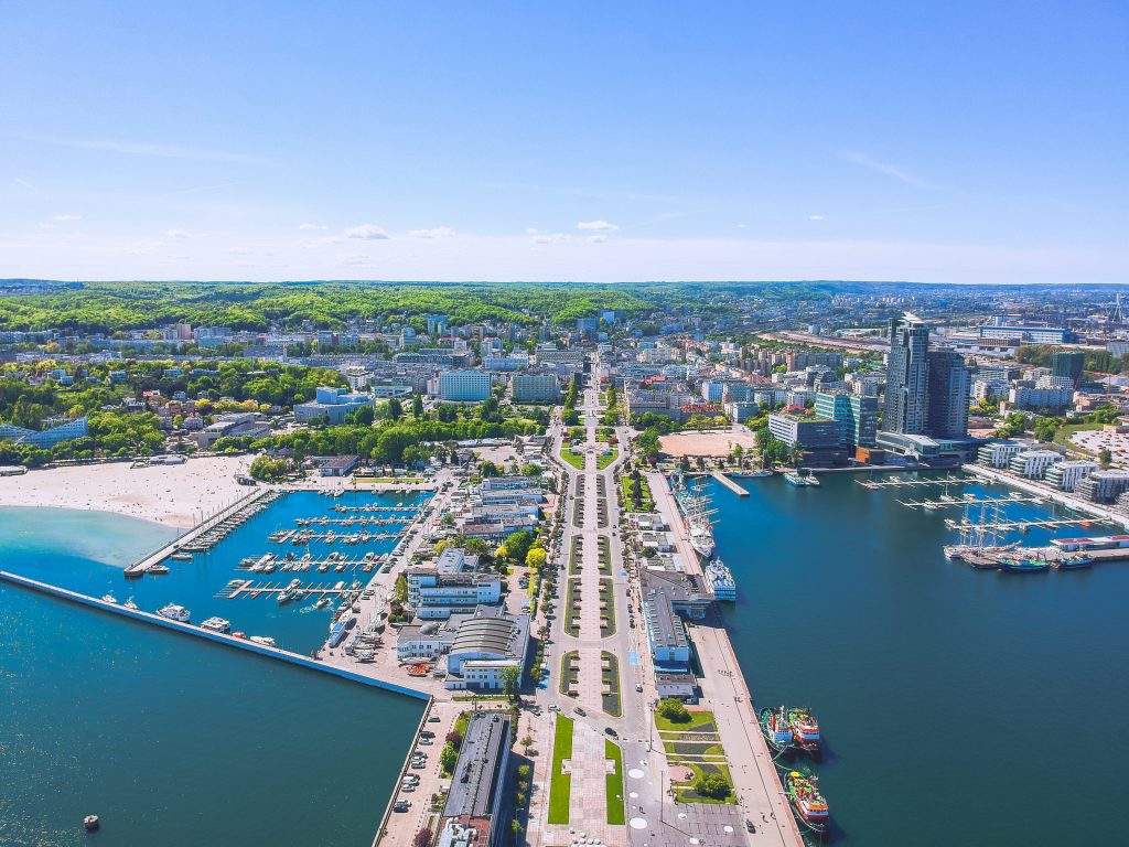 Ein Luftbild, das die symmetrische Hafenstruktur, die zahlreichen Yachten und die zentrale Allee durch das Stadtgebiet zeigt.