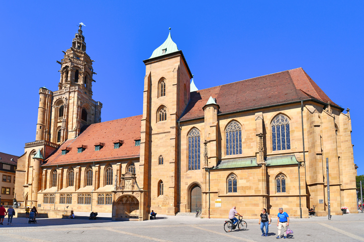 Die imposante gotische Kilianskirche mit ihrem markanten Turm erstrahlt bei strahlend blauem Himmel über einem leeren Marktplatz in Heilbronn.