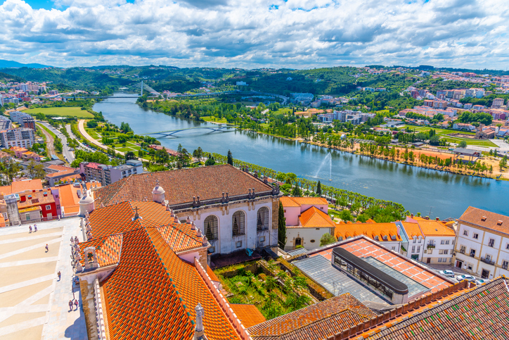 Ein weiter Blick vom historischen Universitätsgelände auf den Fluss Mondego und die moderne Umgebung von Coimbra.