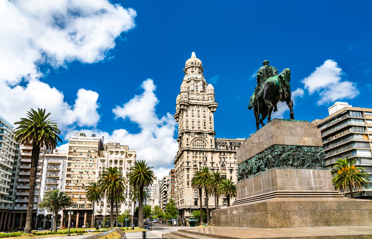 Ein monumentales Reiterstandbild auf einem Platz in Montevideo mit dem beeindruckenden Palacio Salvo im Hintergrund.
