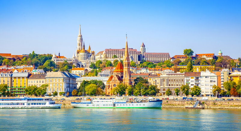 Blick über die Donau auf das Budaer Ufer mit Kirchen, Burgviertel und historischen Gebäuden in Budapest.