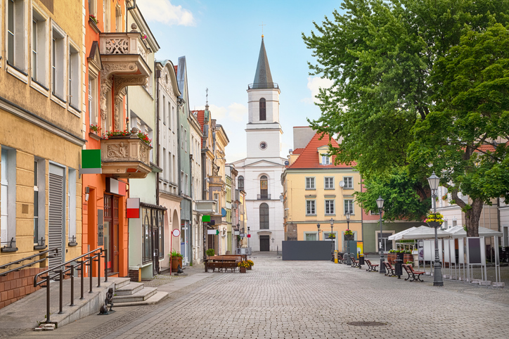 Ein malerischer Platz in Zielona Góra mit einer hohen Kirche im Hintergrund und traditioneller Bebauung.
