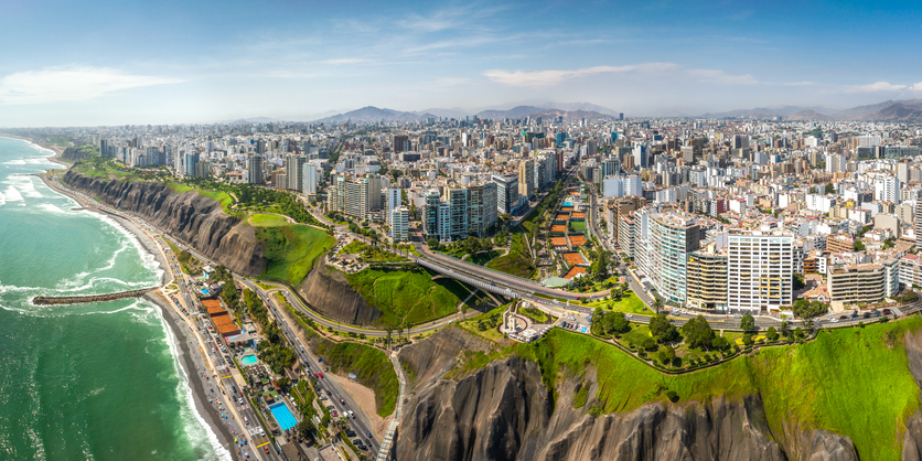 Ein weites Panorama von Lima, das die dichte Bebauung der Stadt entlang der Klippen bis hin zum Horizont zeigt.