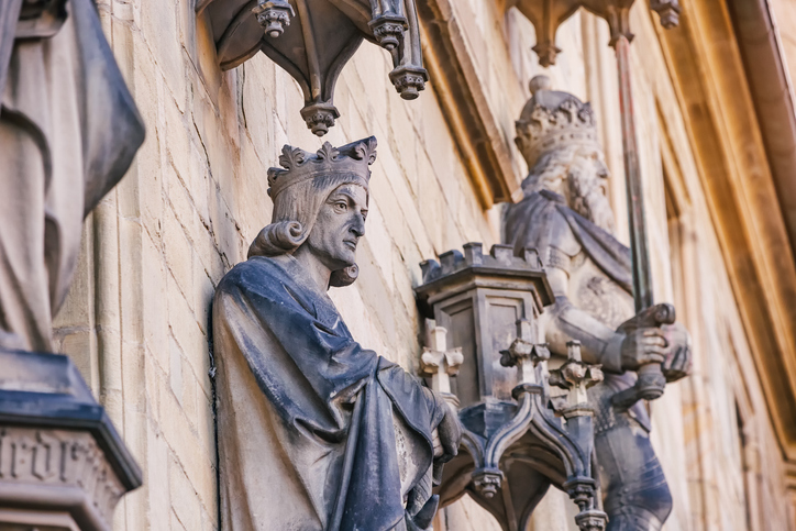 Detaillierte Steinfiguren von historischen Herrschern schmücken die Außenwand des Rathauses von Osnabrück.