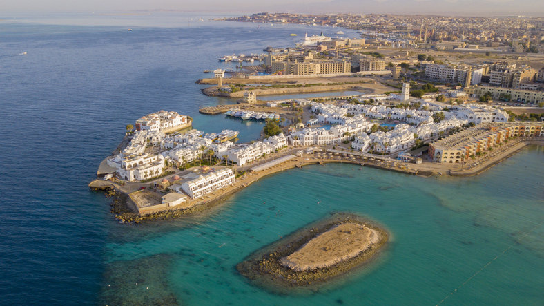 Luftaufnahme der weißen Hotelanlagen und der türkisblauen Bucht von Hurghada.