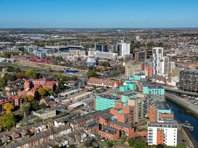 Eine weite Luftaufnahme zeigt das moderne Ipswich mit dem Fluss Orwell, der sich durch die Stadt und ihre Wohngebiete schlängelt.
