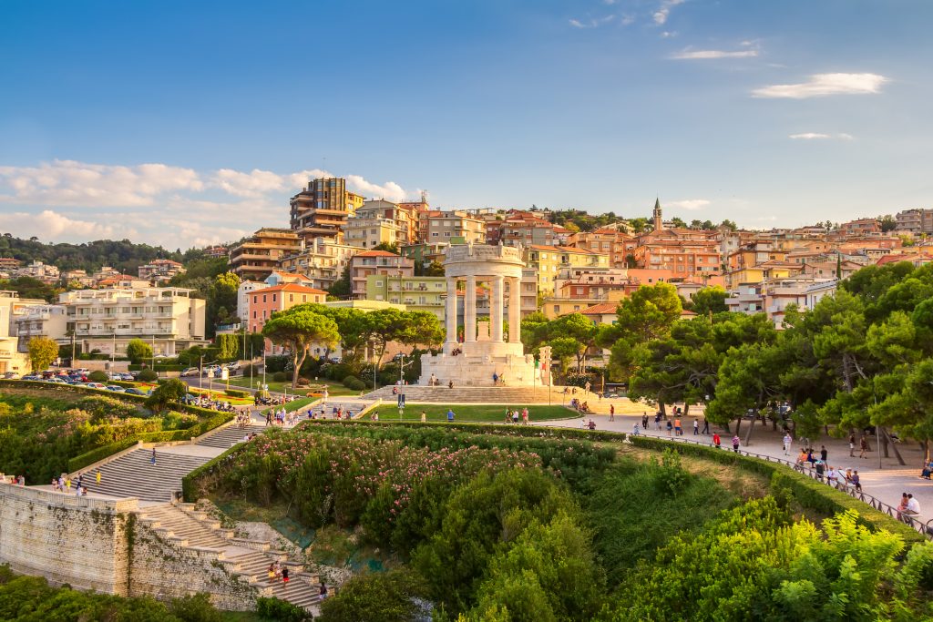Das weiße, monumentale Passetto-Denkmal in einer parkähnlichen Umgebung mit Blick auf die Stadt.