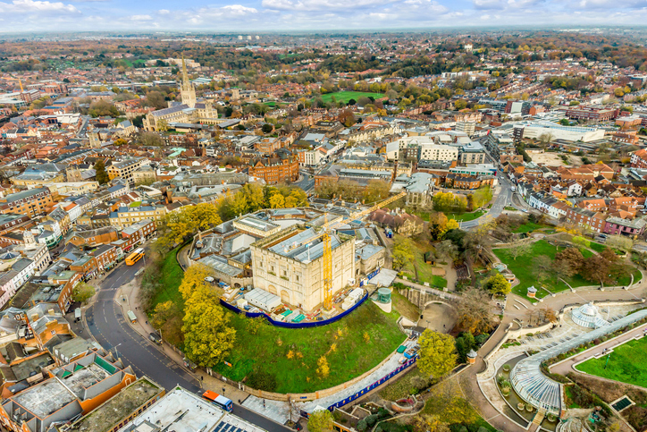 Ein umfassender Blick über die Stadt Norwich mit der prominenten Kathedrale und einem zentralen, historischen Schlossgelände.