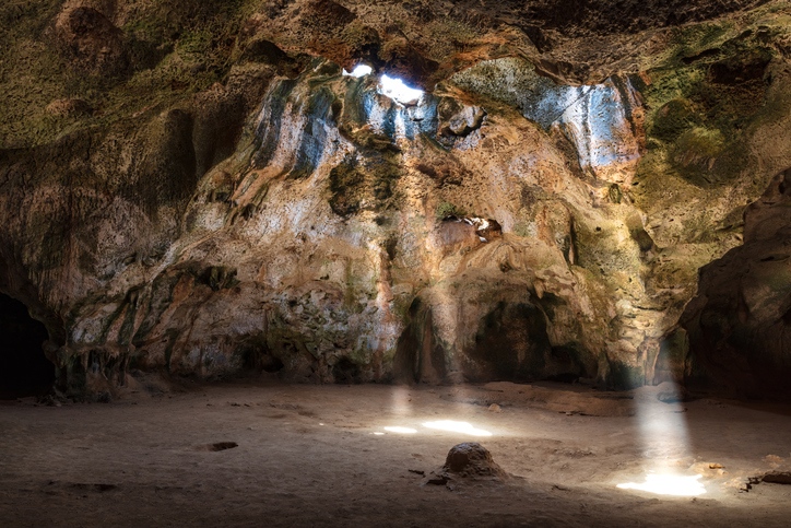 Sonnenstrahlen fallen durch Öffnungen in eine felsige Höhle im Arikok Nationalpark auf Aruba.