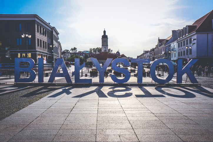 Ein großer, blauer Schriftzug mit dem Namen „BIAŁYSTOK“ steht auf einem zentralen Platz vor einer historischen Kulisse.