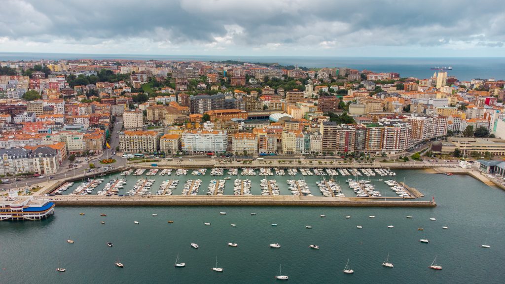 Eine Luftaufnahme zeigt den großen Yachthafen von Santander, gefüllt mit vielen Booten vor einer dichten Stadtbebauung.