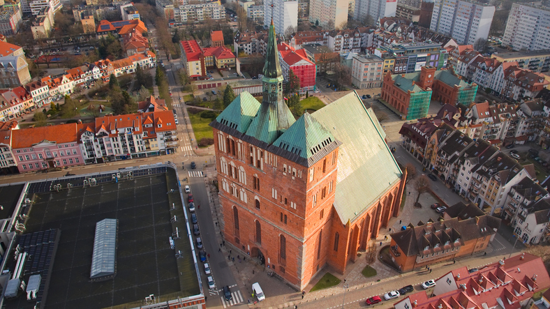 Die markante, rote Backsteinfassade der gotischen St.-Marien-Kathedrale prägt das historische Zentrum von Kolberg.