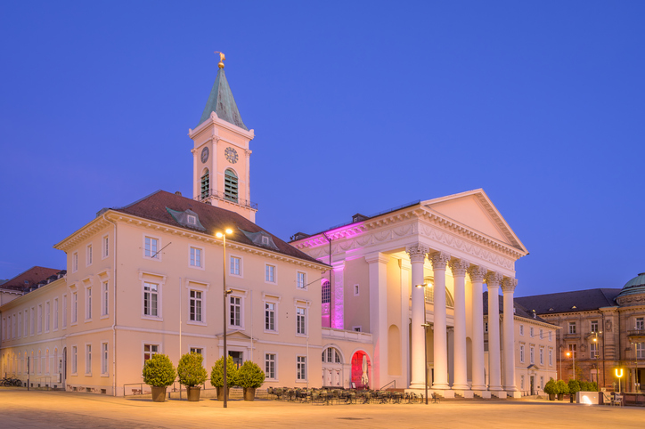 Die evangelische Stadtkirche am Marktplatz in Karlsruhe wird in der Abenddämmerung stimmungsvoll beleuchtet.