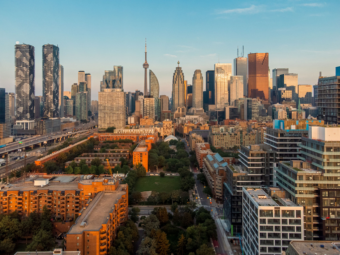 Die Skyline von Toronto mit dem CN Tower leuchtet im warmen Abendlicht.