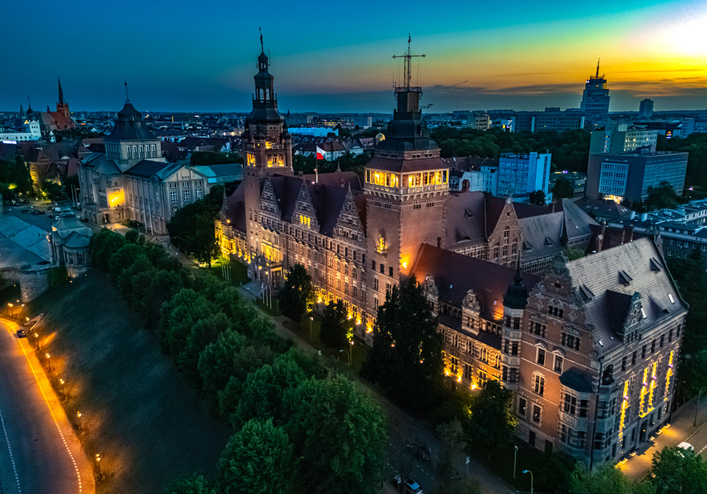 Ein prachtvolles historisches Gebäude erstrahlt in der Abenddämmerung hell beleuchtet unter einem tiefblauen Nachthimmel.