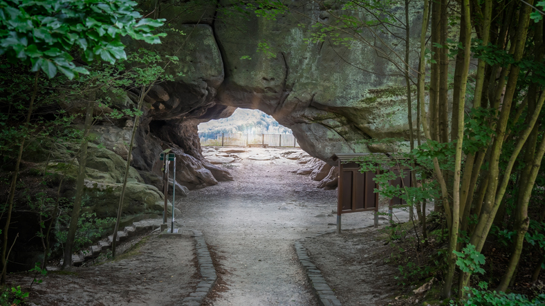 Ein natürlicher Felsdurchgang führt durch den Wald im Nationalpark Sächsische Schweiz.