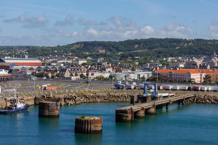 Der industrielle Bereich des Hafens von Cherbourg mit Anlegestellen und der dahinter liegenden Stadt.