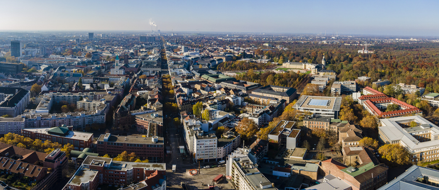 Ein weiter Blick von oben über die dicht bebaute Stadtlandschaft von Karlsruhe mit dem Schloss im Hintergrund.