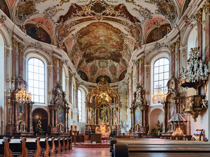 Das detaillierte, barocke Innere einer Mainzer Kirche mit aufwendigen Deckengemälden, goldenen Verzierungen und einer prunkvollen Kanzel.