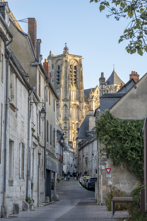 Eine schmale Straße in Bourges führt direkt auf die imposante Fassade der Kathedrale zu.
