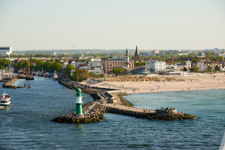 Eine Ansicht von oben auf die Molen von Warnemünde mit dem Leuchtturm und dem anliegenden Fährverkehr.