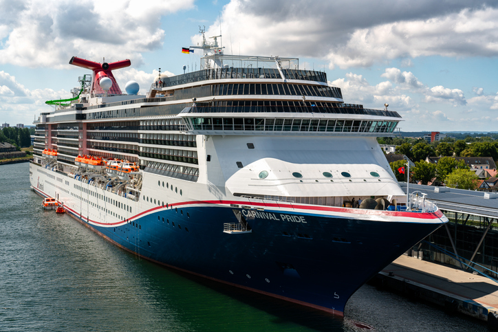 Ein großes Kreuzfahrtschiff liegt sicher vertäut am Pier im Hafen von Warnemünde.