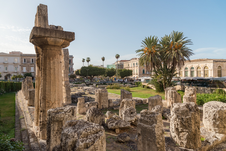Ein Blick auf die archäologischen Überreste der Tempelanlage in Syrakus mit einer markanten Säule im Vordergrund.