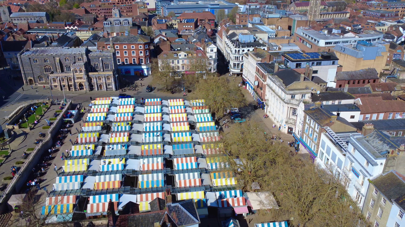 Eine Luftansicht der geordneten Marktstände in Norwich mit ihrer bunten Dachgestaltung mitten in der Stadt.