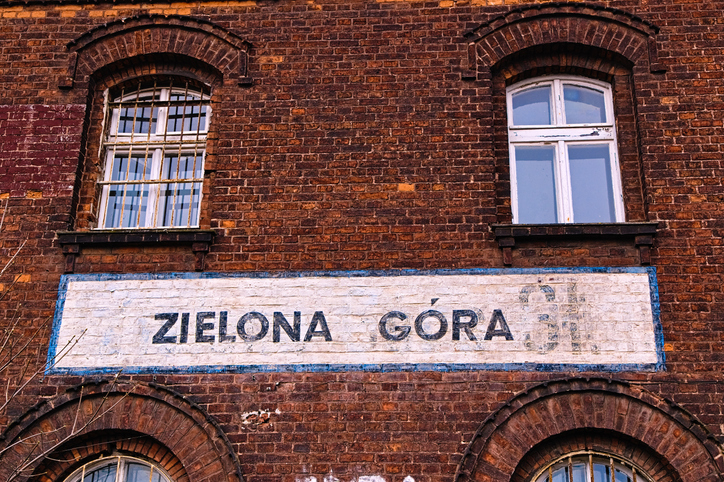 Detailansicht einer roten Backsteinfassade mit der Aufschrift "Zielona Góra" auf einem alten Schild.