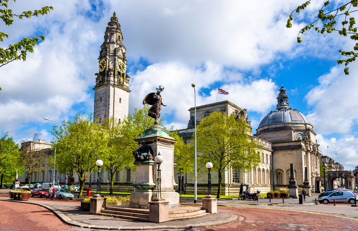 Die Cardiff City Hall mit Uhrturm, Kuppel und Reiterdenkmal steht an einem grünen Platz.
