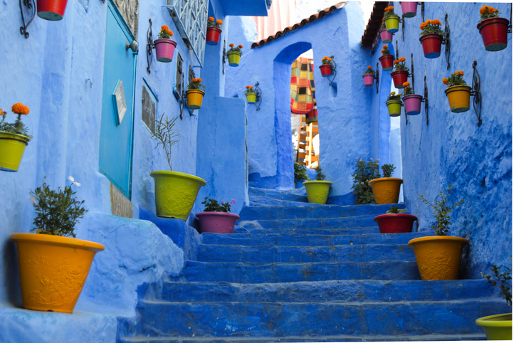 Eine blaue Gasse mit Treppen, Blumentöpfen und marokkanischem Flair nahe Tanger.