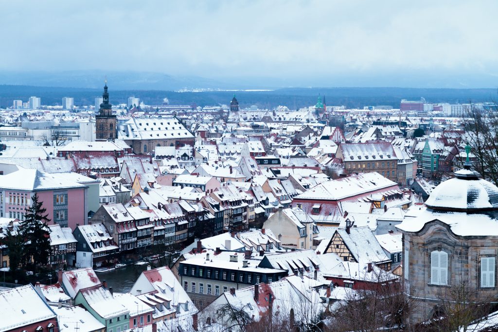 Die Dächer der gesamten Stadt sind tief verschneit und bieten einen malerischen Anblick unter einem grauen Winterhimmel.
