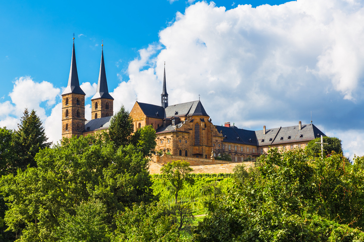 Das imposante Kloster Michelsberg thront auf einem Hügel über den grünen Weinbergen von Bamberg.