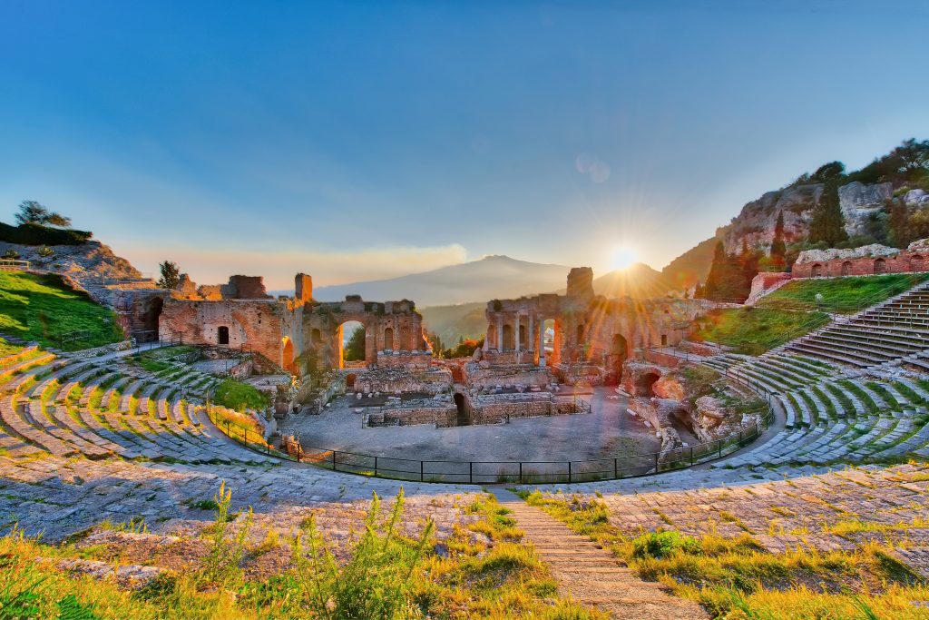 Blick über die antiken Ruinen des Theaters in Taormina bei Sonnenaufgang mit dem Ätna im Hintergrund